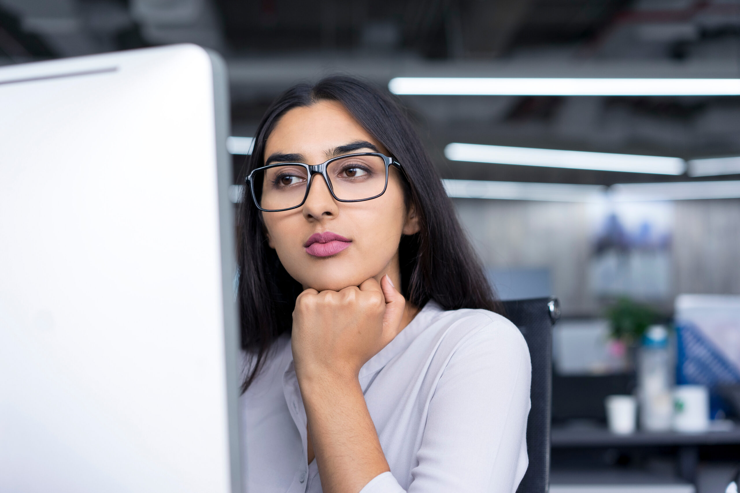 Serious young businesswoman working at computer