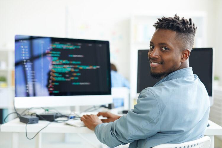 happy male computer programmer at his workstation.