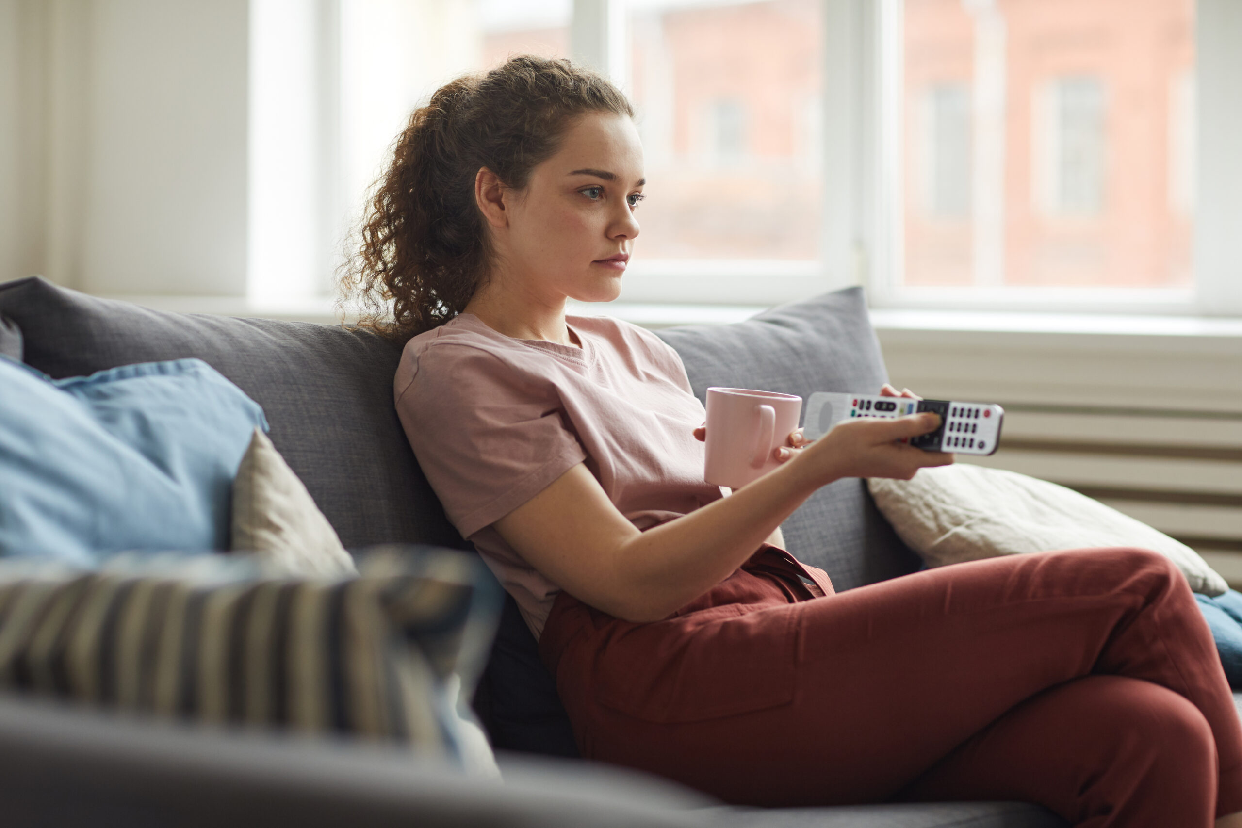 Young woman watching tv at home