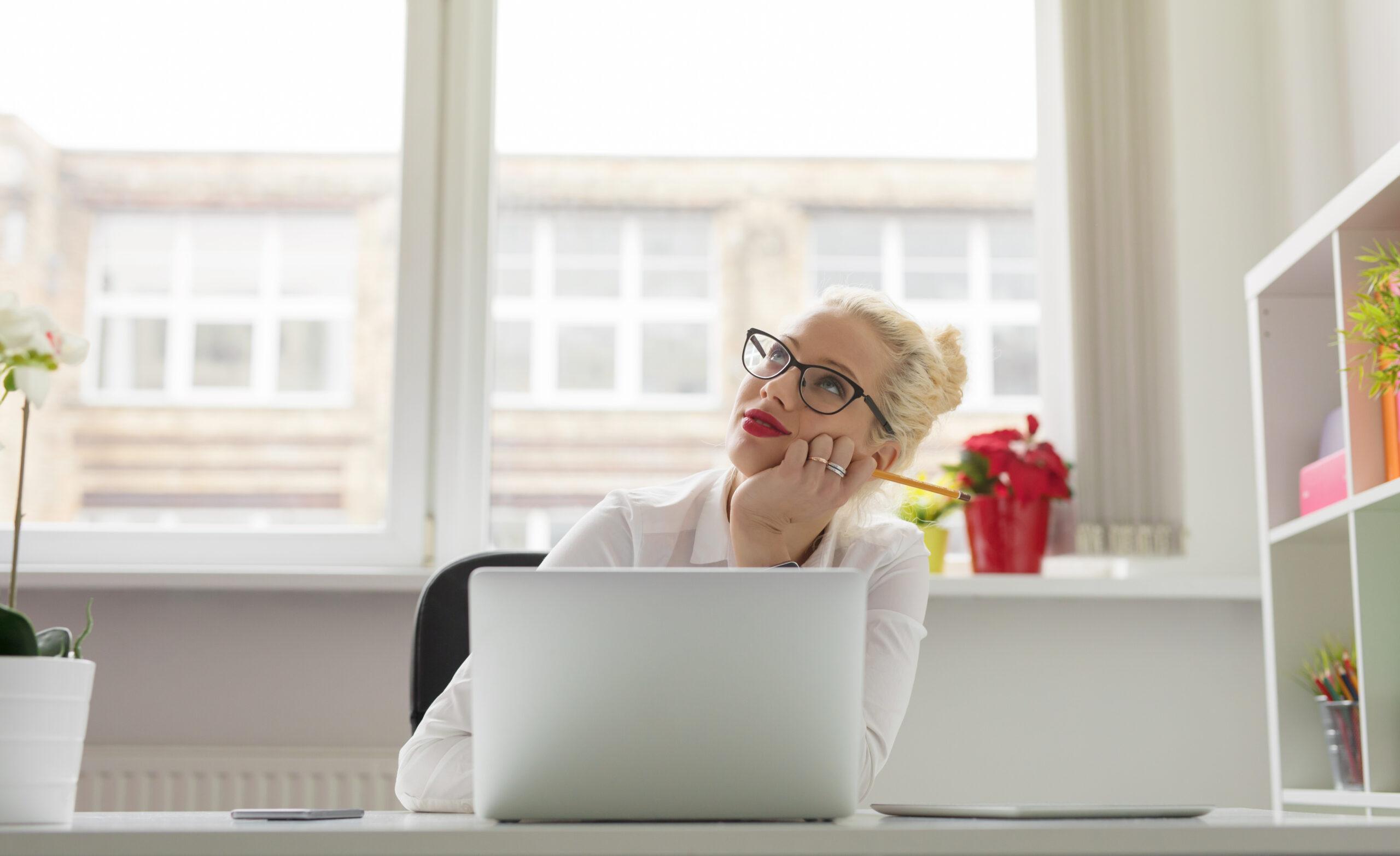 woman thinking in front of her laptop