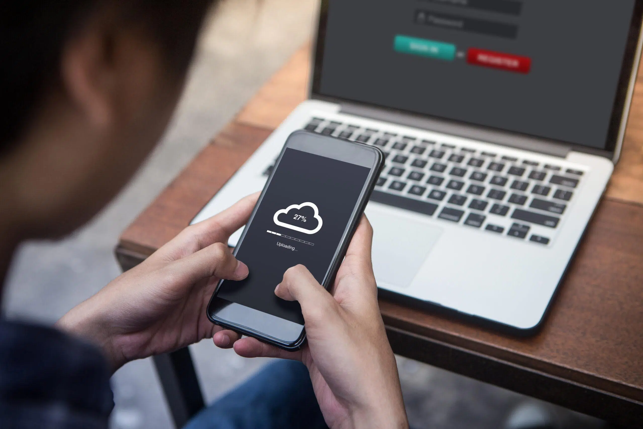 Man using his phone to upload files to the cloud 