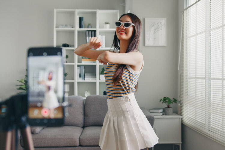 Asian young woman tiktoker created her dancing video by smartphone