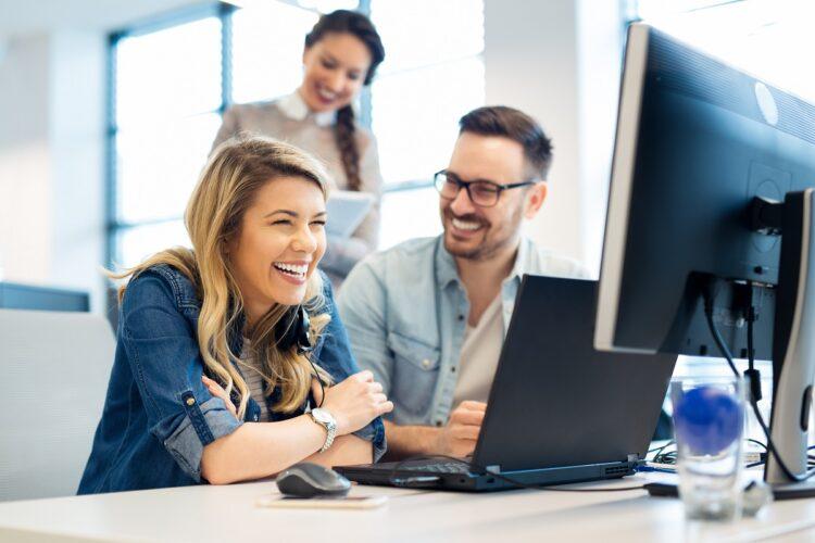 A happy looking group of computer programmers working together