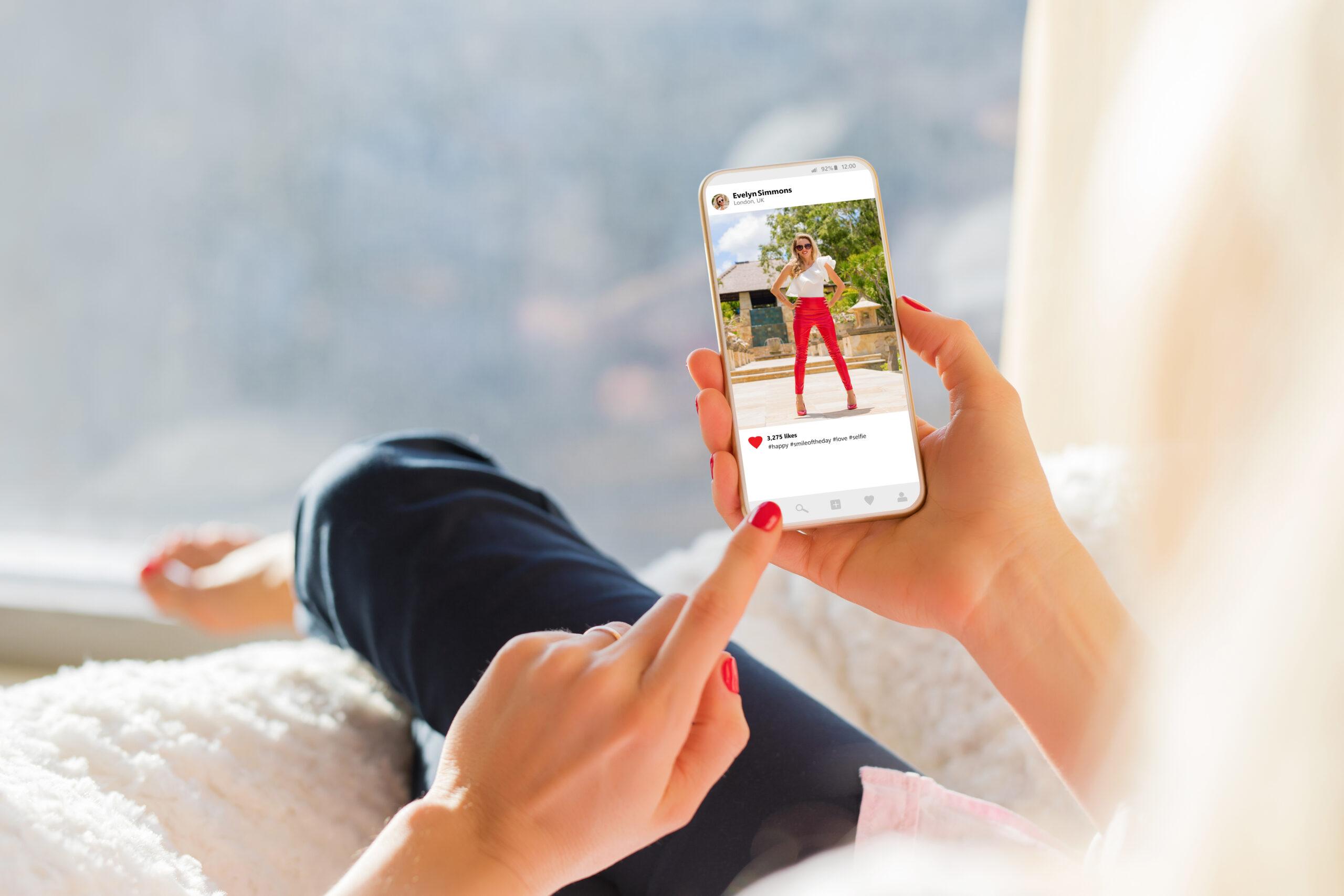 Woman looking at photo sharing app on mobile phone