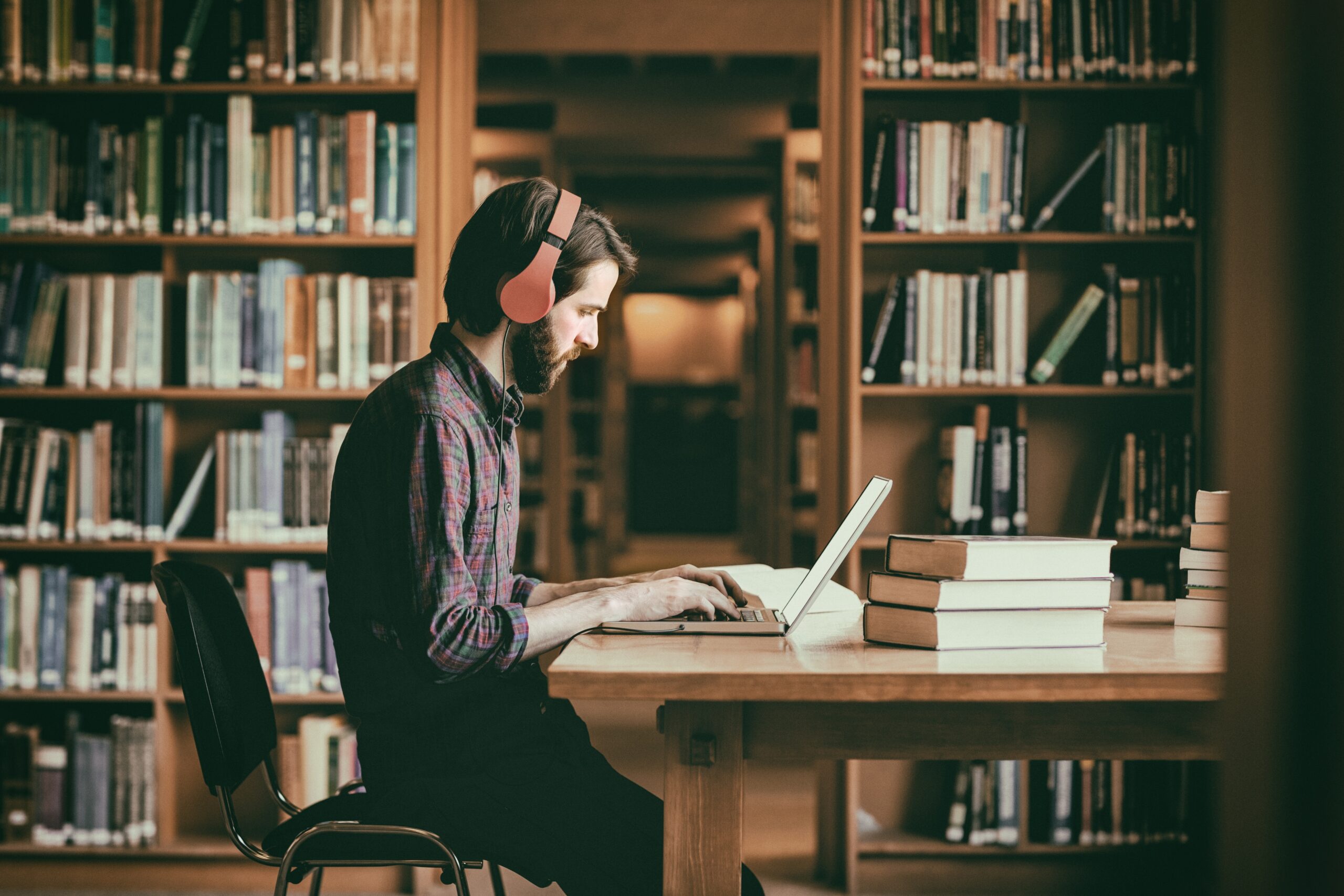 Hipster male student studying in library