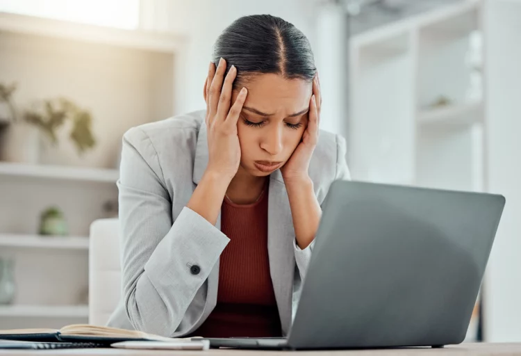 career woman looking stressed at work in front of computer