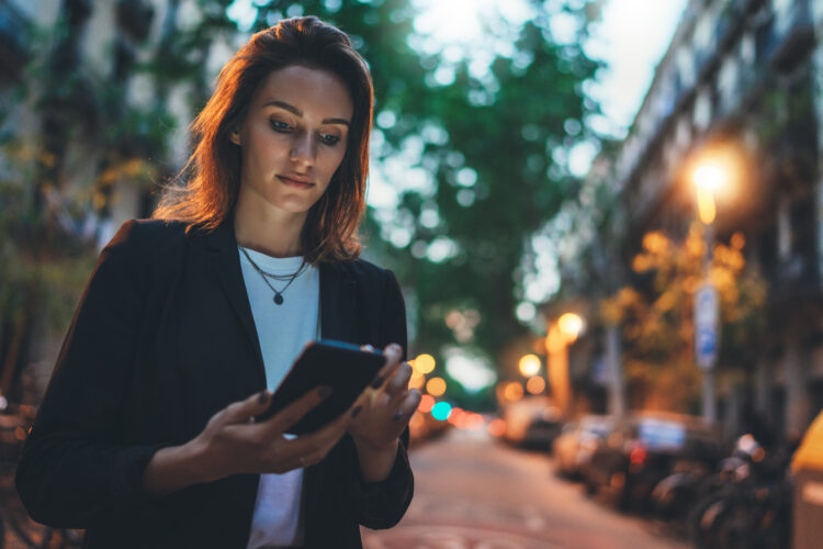 Woman sends text message outdoor