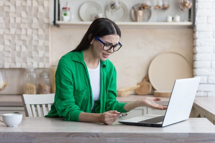 Woman frustrated while looking at laptop