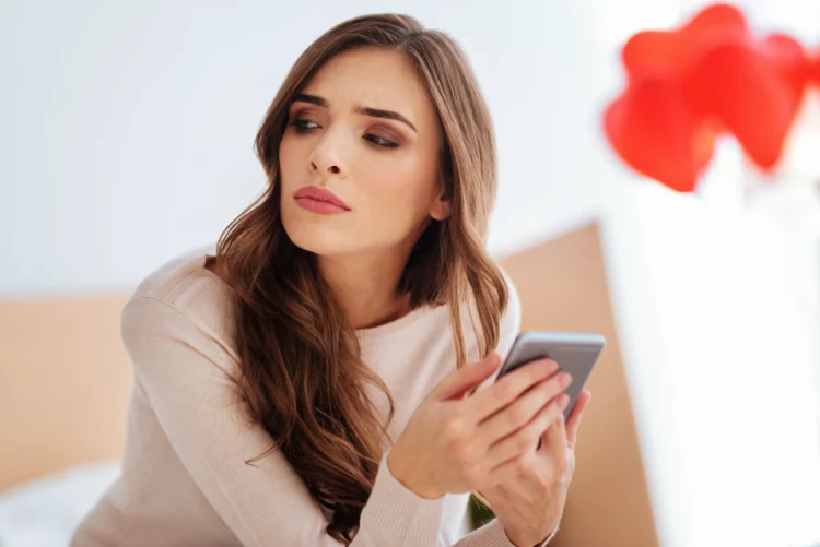 Serious lady thinking about something while using phone
