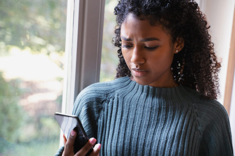 frustrated young woman looking at her cellphone