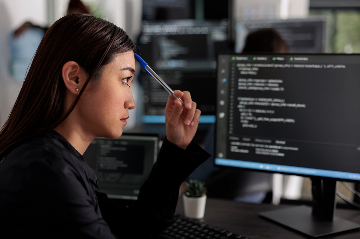 Pensive young female programmer at work