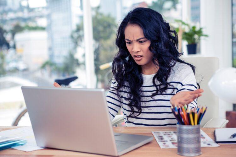 Frowning woman looking at laptop