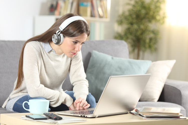 girl with headphones using laptop