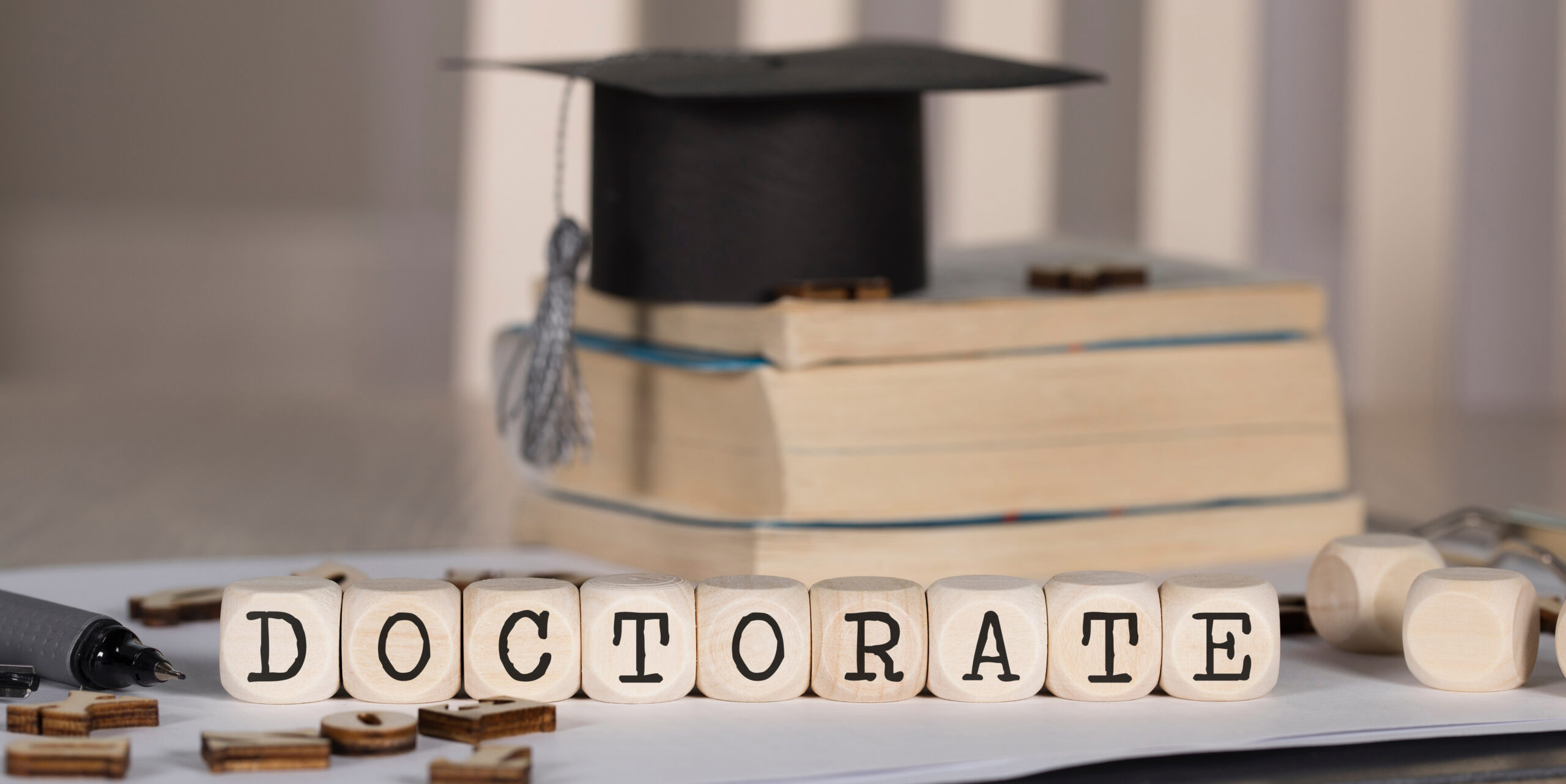 The word DOCTORATE on wooden dices