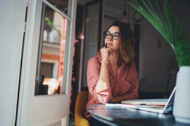 Beautiful woman thinking about something while sitting at work