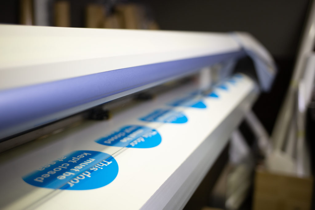 Wide-format inkjet printer with stickers.