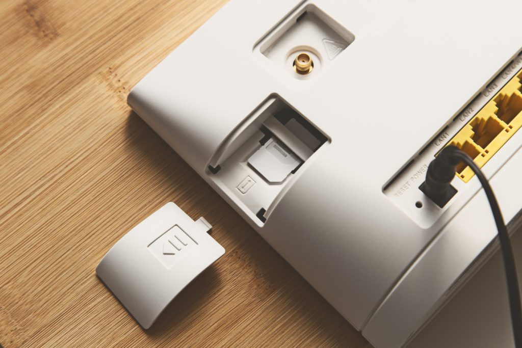 A wifi modem router with sim card slot on a wooden table top.