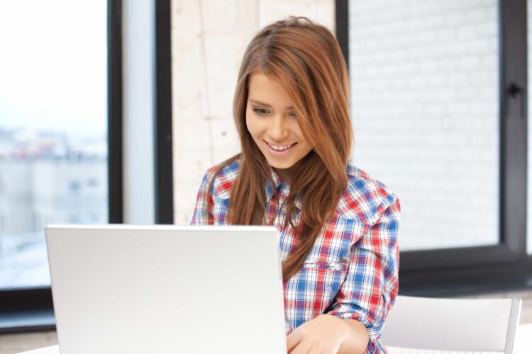 Woman on laptop trying to figure out why facetime is not working on wifi.