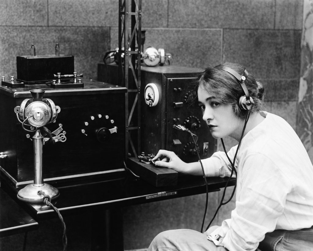 Woman sending morse code using a telegraph, old photograph.