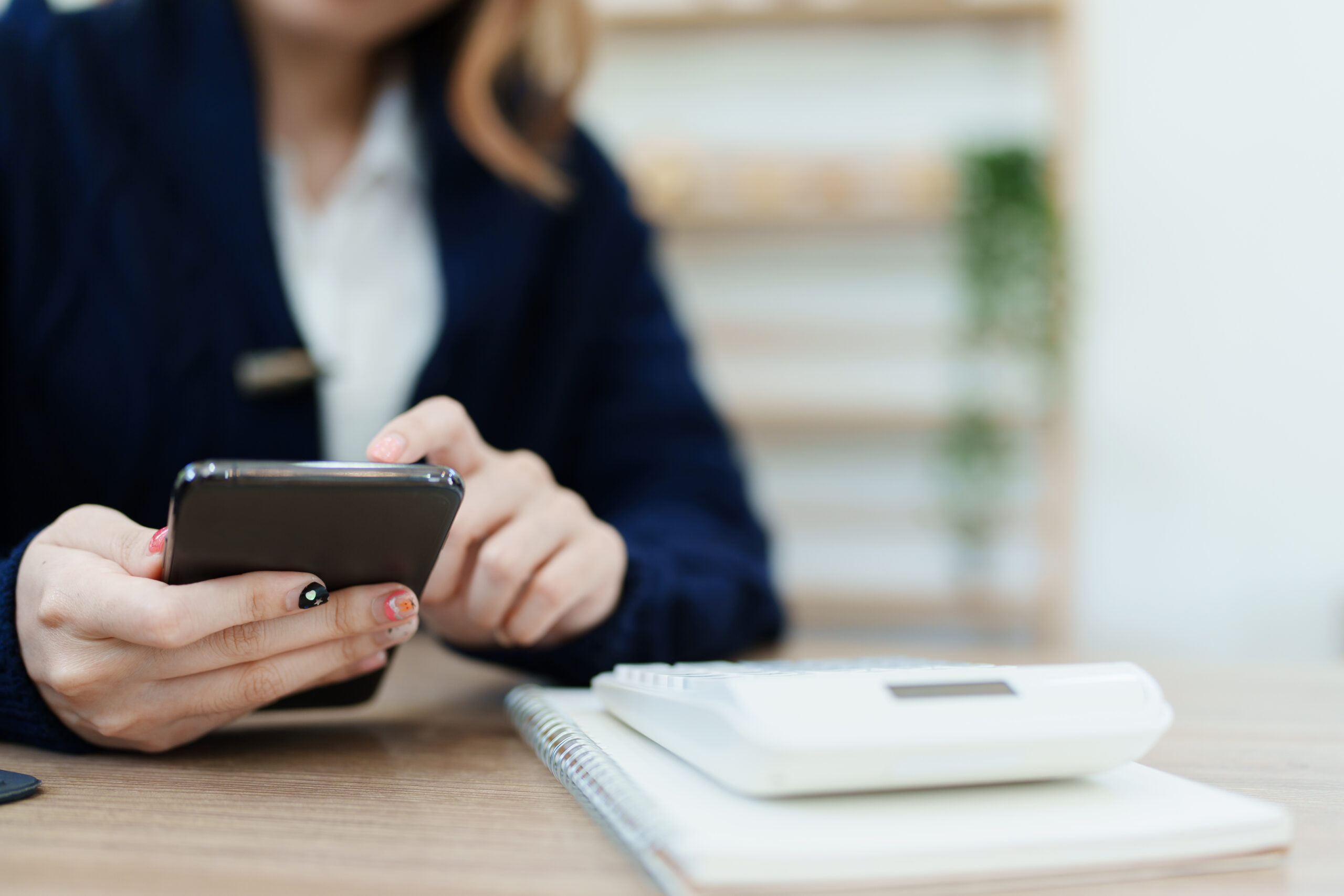 woman checking her cellphone at desk