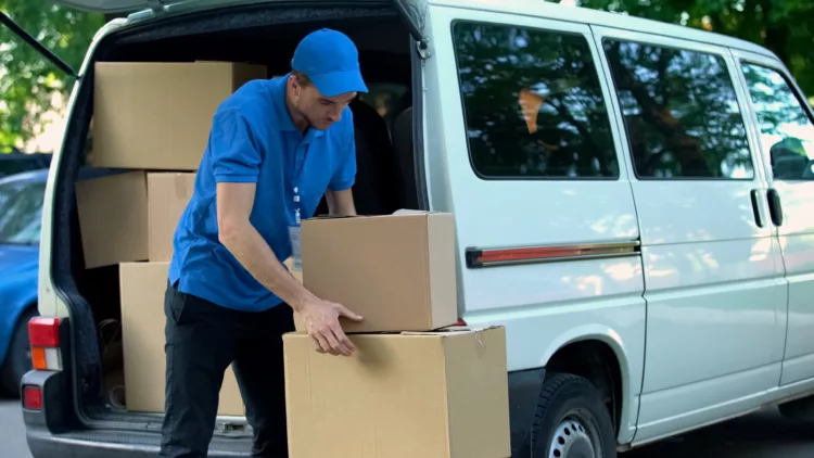 Courier taking boxes out from delivery van