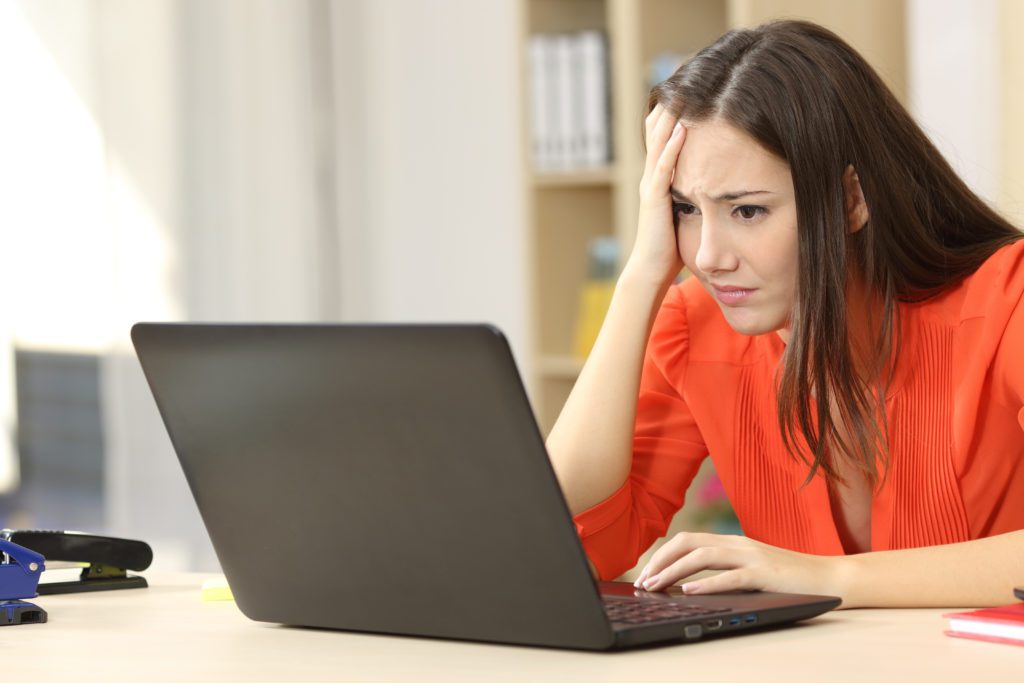 Worried woman entrepreneur looking at her laptop.