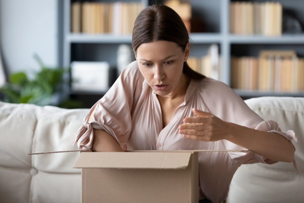 Woman surprised and confused after unboxing parcel.