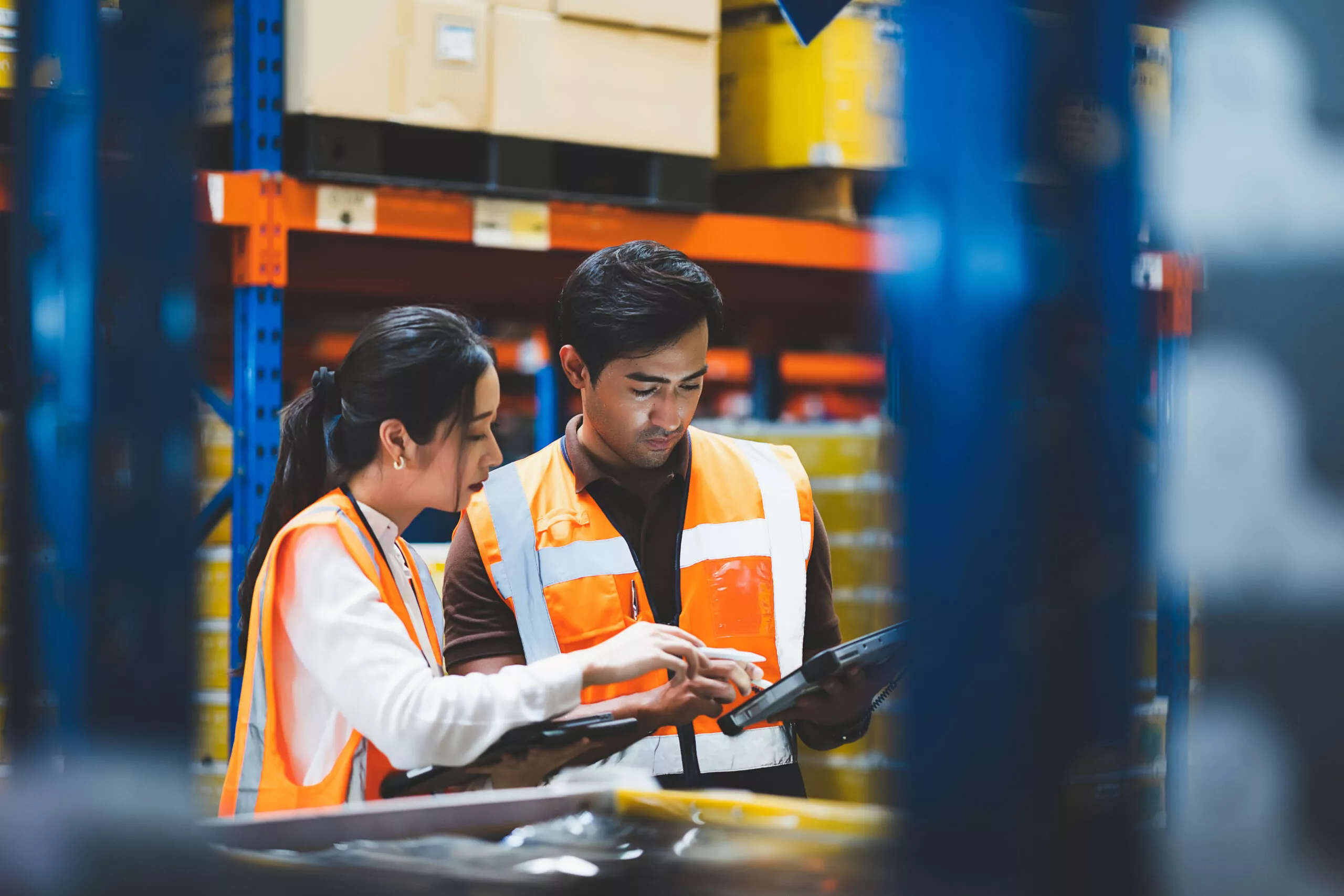 warehouse worker and manager checks stock and inventory using a tablet device