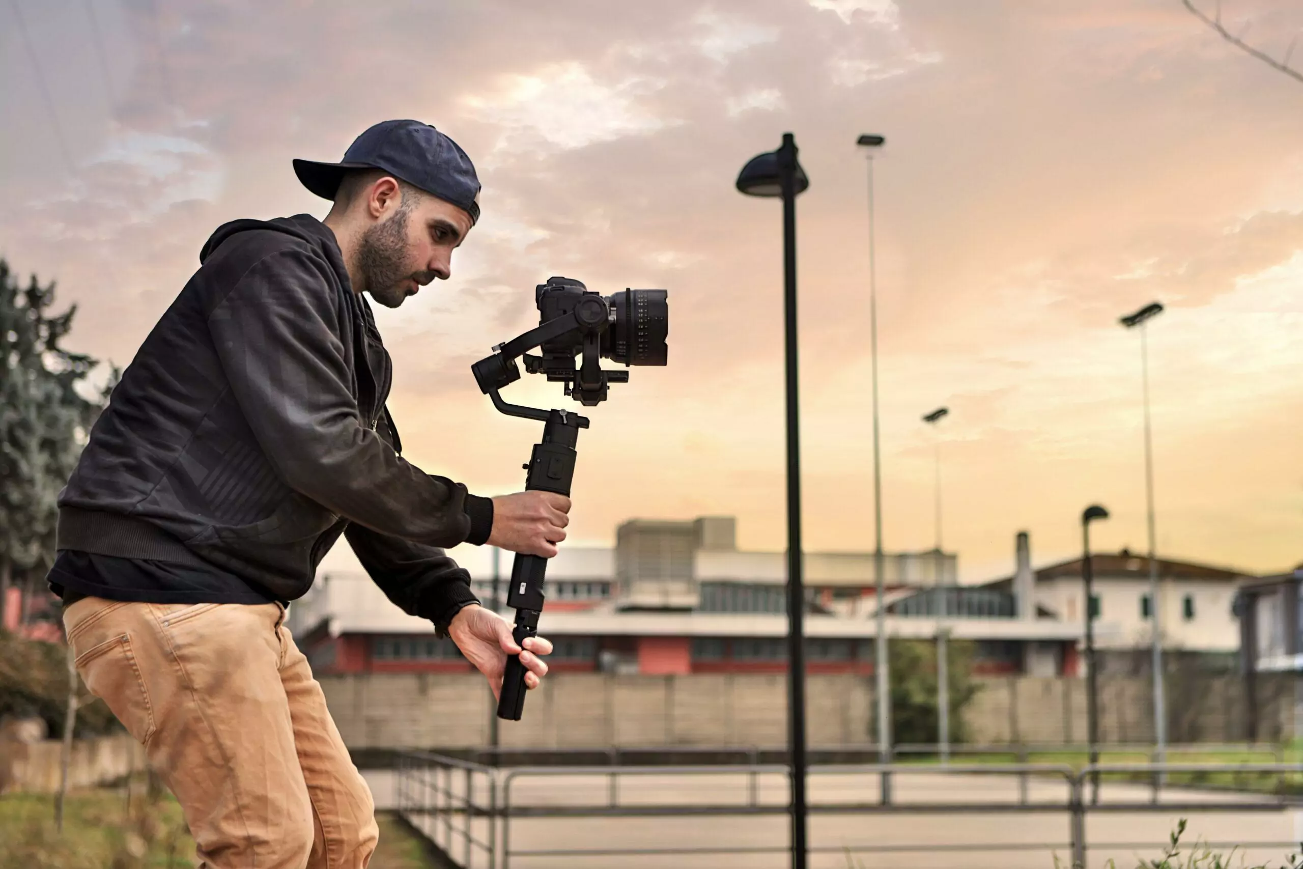 Caucasian videographer filming with cinema gimbal video dslr at