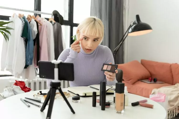 Blonde girl recording a makeup tutorial for her followers