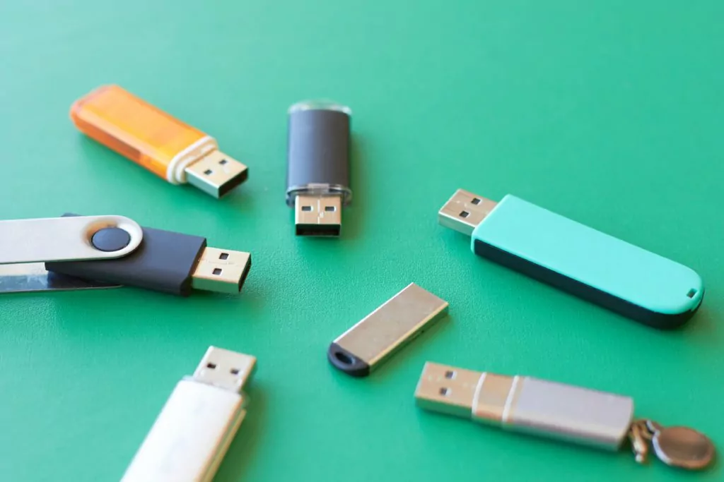 Assorted USB flash drives in green background.