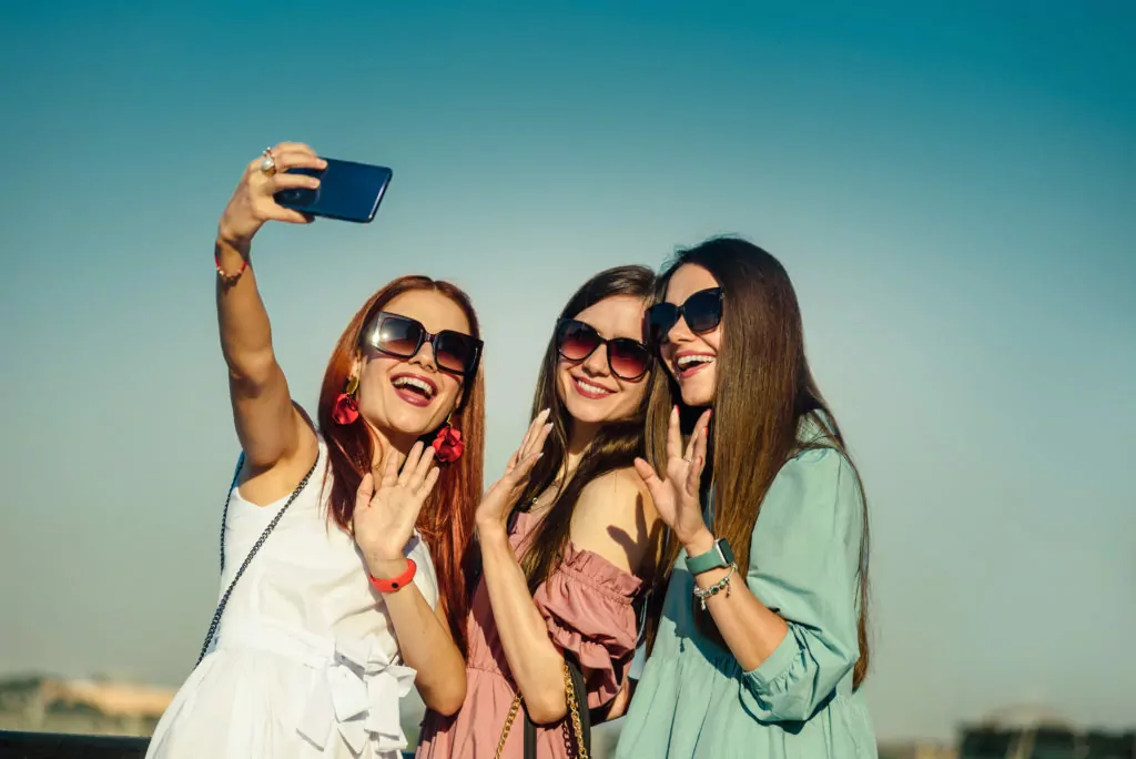 Beautiful young girls taking a selfie outdoor.