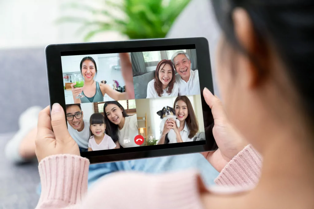 Girl using tablet while having a video call with family.
