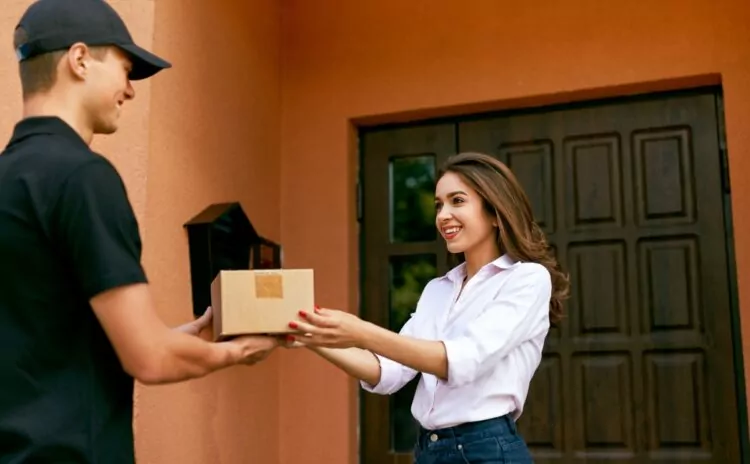 A young beautiful woman accepting a package from a delivery man