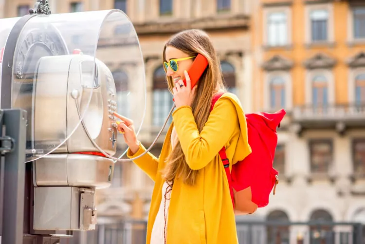 Woman calling using a pay telephone on the street.