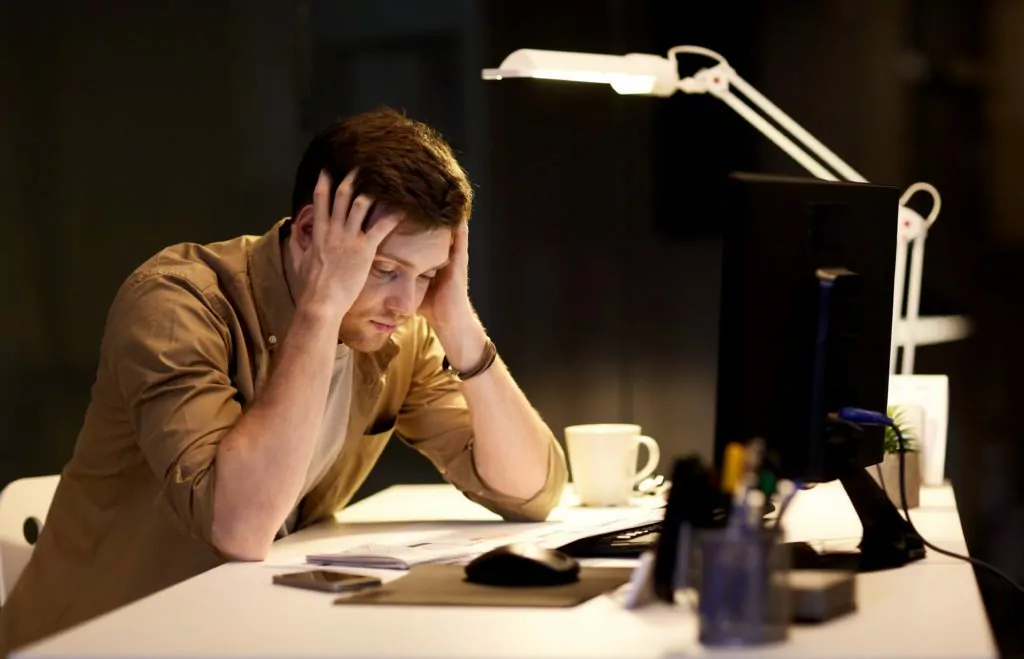 Man stressed while working late at night in the office.