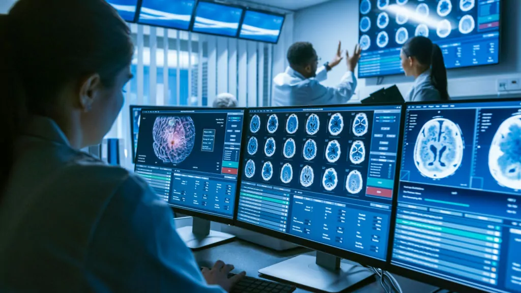 Medical scientist working with brain scans on computer screens inside the laboratory.
