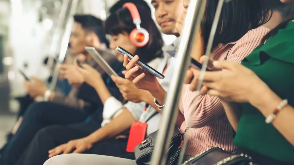 People using mobile phones in public underground train.
