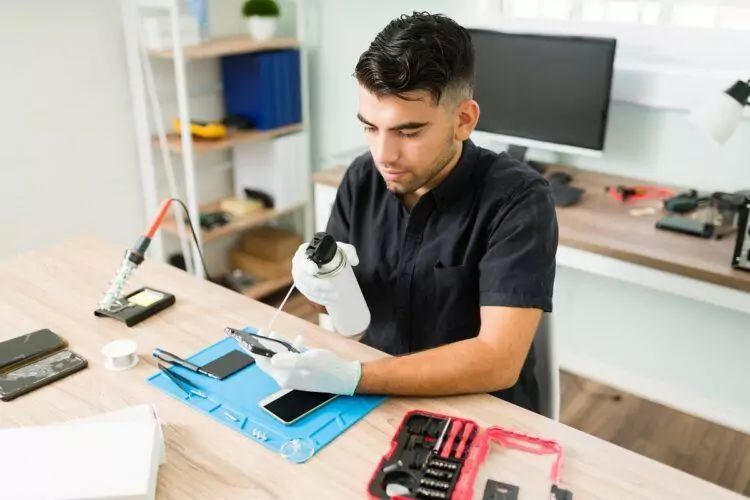 Professional technician cleaning and fixing a smartphone