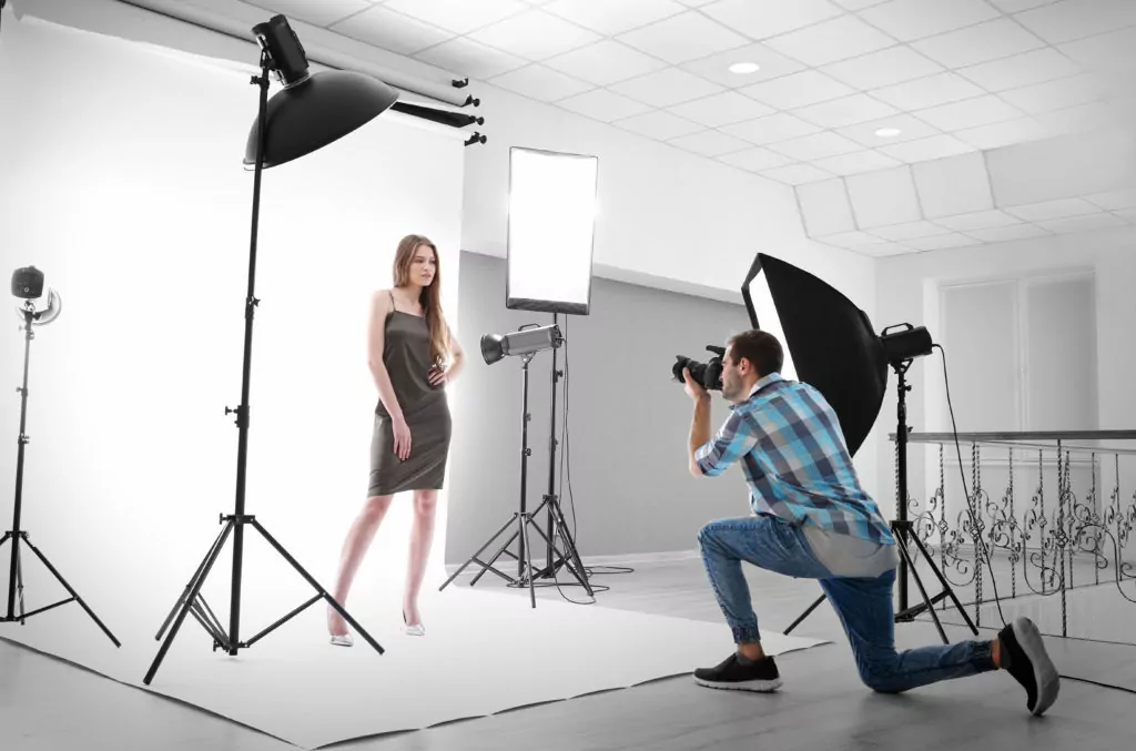Photographer taking pictures of a model in studio