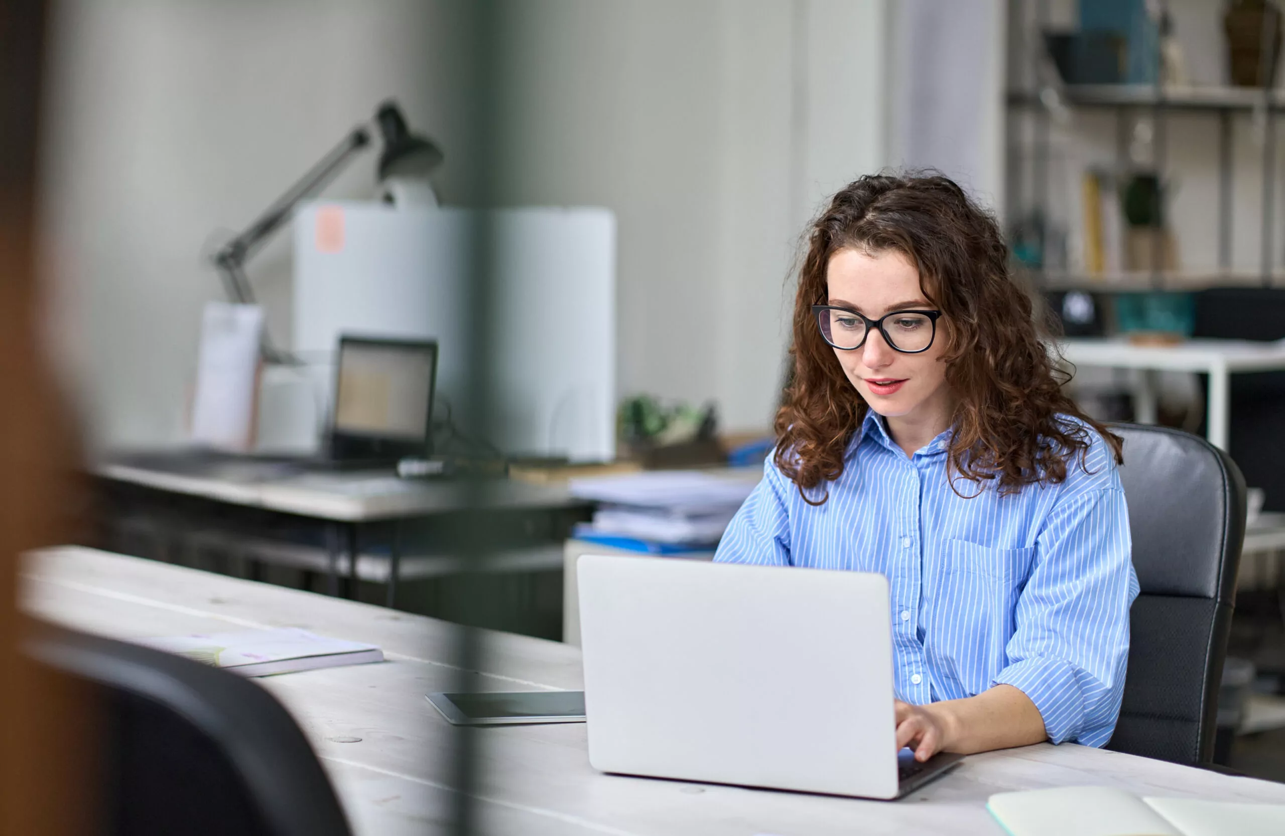 Young business woman worker working using laptop in modern office 