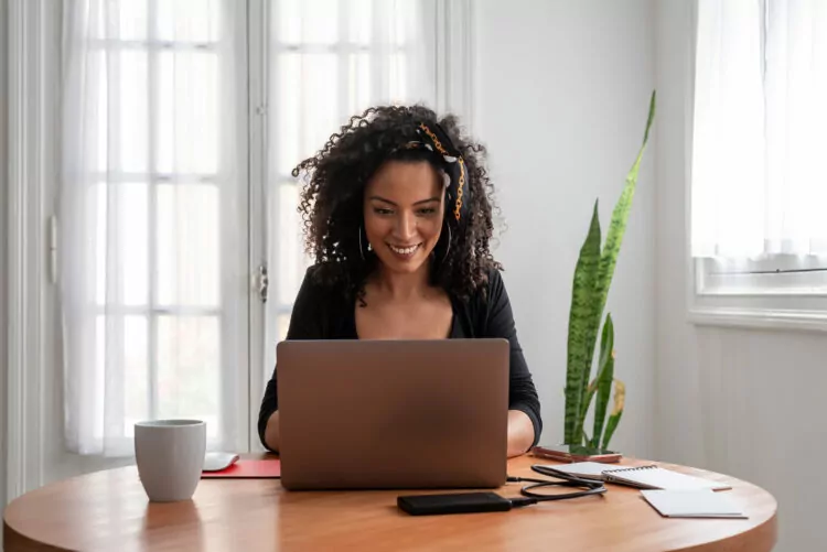 young woman working at home with laptop and documents
