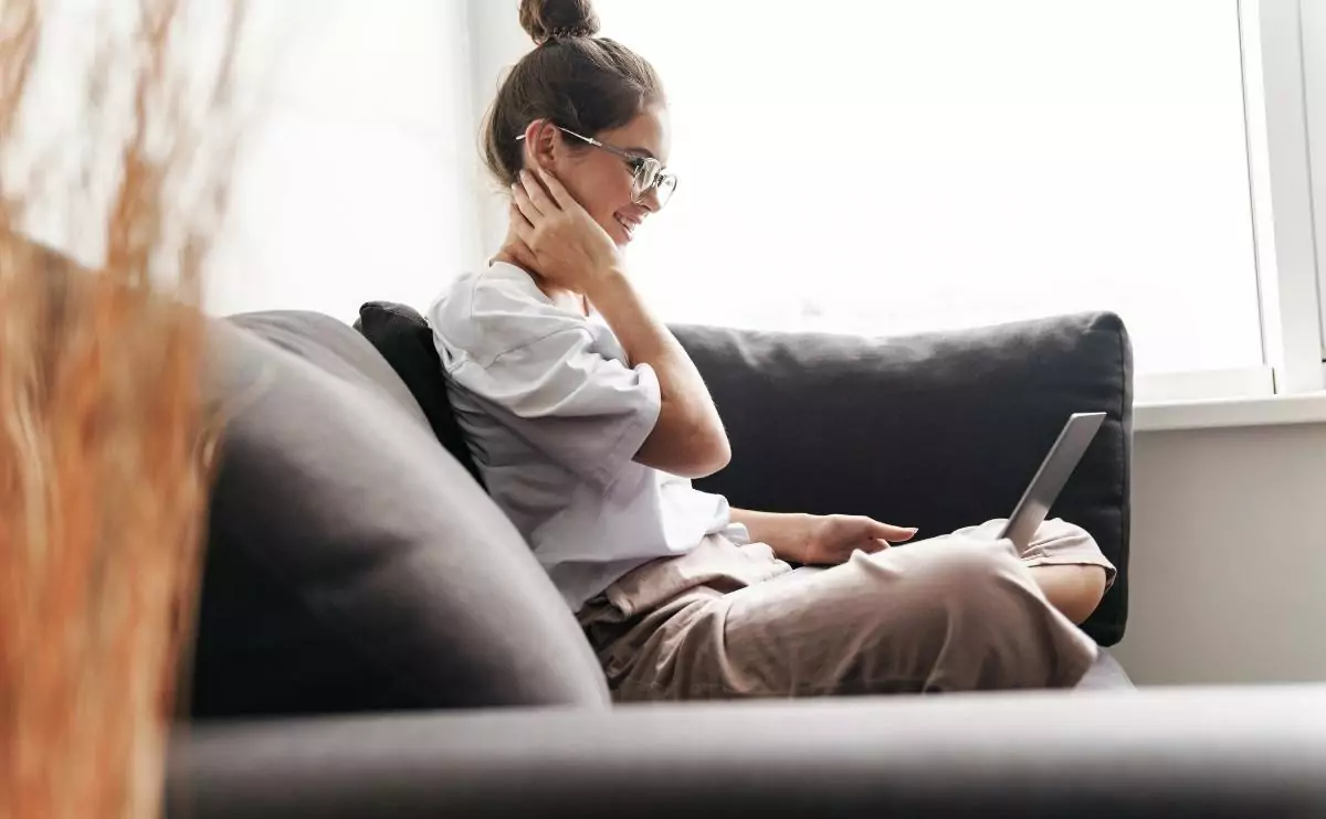 young woman sitting on the couch with laptop