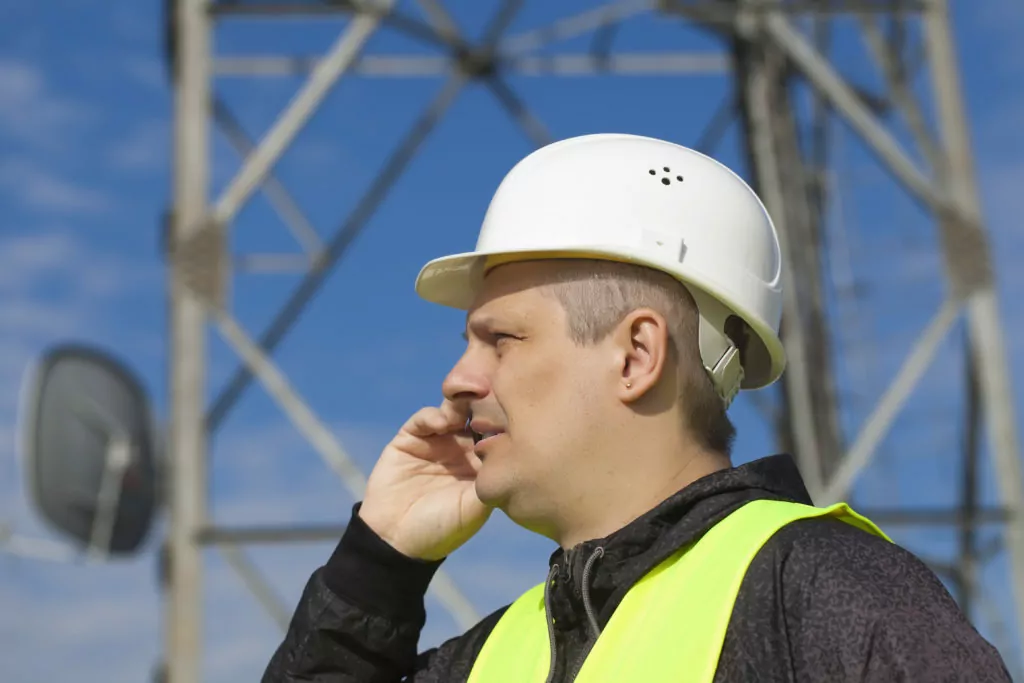 Engineer talking on the cell phone near to gsm tower
