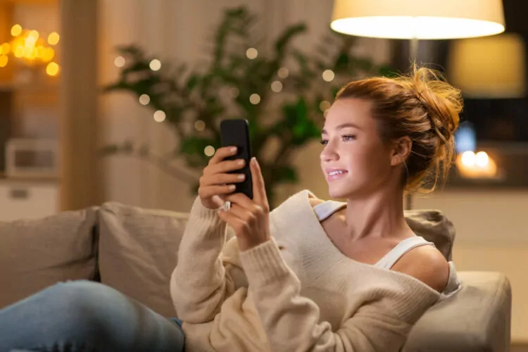happy young woman with smartphone at home