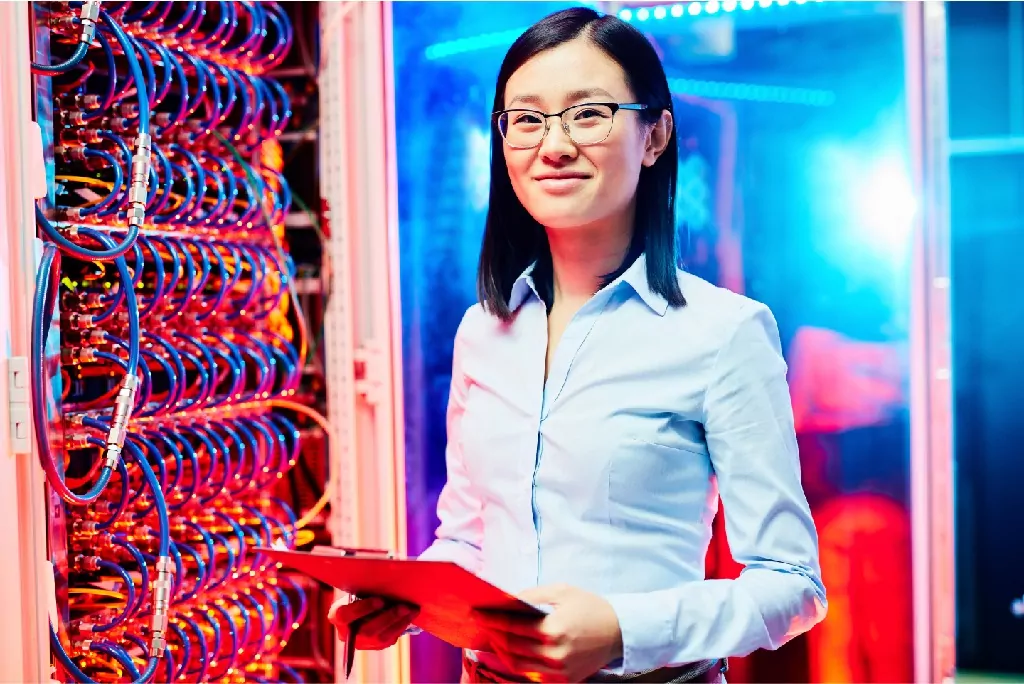 Researcher in supercomputer center in front of blinking ethernet lights.